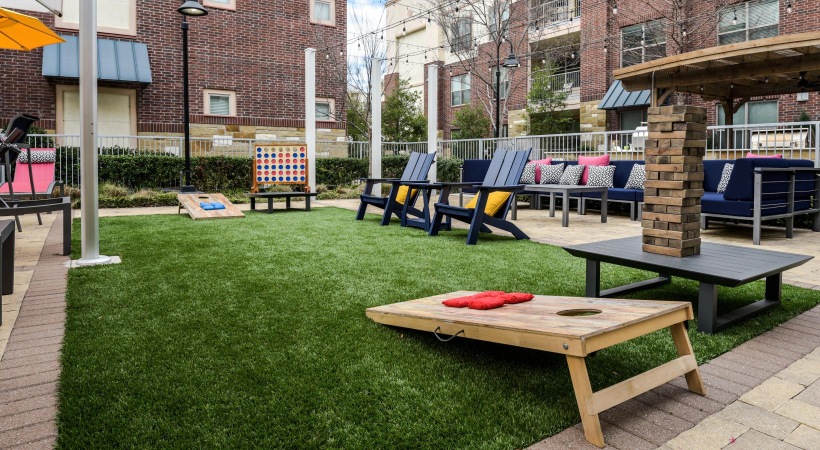 a group of picnic tables in a park with High Line in the background